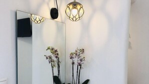 A bathroom with a white vanity, a large mirror, two potted orchids, and two pendant lights. - Studios Taki's Place (Naxos)