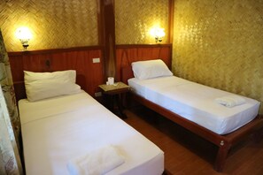 Two single beds with white linens, wooden headboards, and a nightstand with a lamp between them. - Villa Israel Ecopark El Nido by Cocotel Powered by Fave (El Nido)