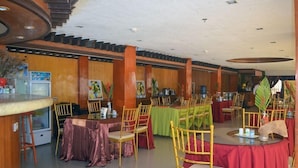 A restaurant with multiple tables and chairs, wooden walls, and ceiling lights. - Villa Israel Ecopark El Nido by Cocotel Powered by Fave (El Nido)