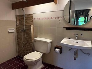 A bathroom with a toilet, a sink, and a shower. - Maesa Valley Garden Resort & Craft Village (Mae Rim)