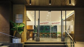 A hotel entrance with a staircase, a sign indicating a smoking area, and a reception desk. - Ginger Andheri East (Mumbai)