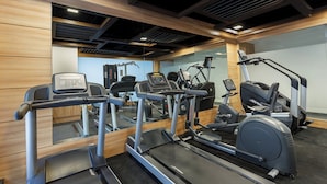 A gym with treadmills, elliptical machines, and weight equipment. - Ginger Andheri East (Mumbai)