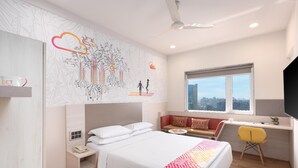 A modern hotel room with a large bed, a desk, and a view of the city. - Ginger Andheri East (Mumbai)