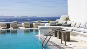 Ein Poolbereich mit Blick auf das Meer und ferne Berge.