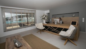 Un comptoir d’accueil moderne offrant une vue sur une piscine et le paysage urbain.