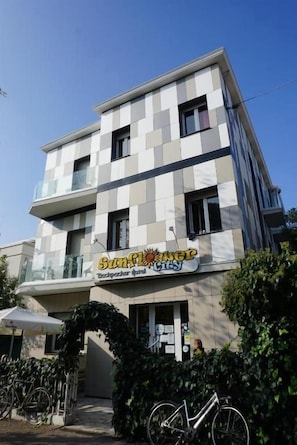 Un edificio de varios pisos con un letrero que dice 'Sunflower City Backpacker Hotel'.