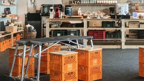 Een keuken met houten kastjes, een koffieapparaat en oranje dozen.