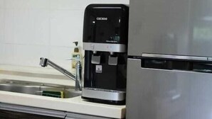 Een keuken met een koffiezetapparaat en een roestvrijstalen koelkast.