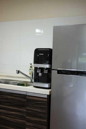 Een keuken met een koffiezetapparaat en een roestvrijstalen koelkast.