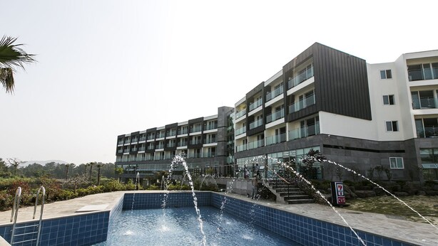 Een modern gebouw met een zwembad en waterpartijen.
