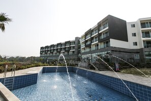 Um edifício moderno com piscina e elementos aquáticos.