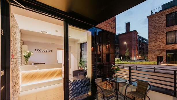 A modern building with a reception area labeled "EXCLUSIVE APARTMENTS". - Exclusive Apartments (Kraków)