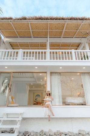 A two-story building with a balcony, large windows, and a thatched roof. - Stories Stay Pool Villa Khao-tao Huahin (Tambon Nong Kae)
