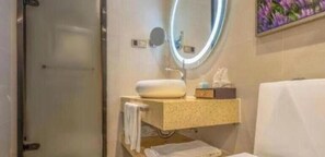 A bathroom with a sink, mirror, and towel rack. - Lavande Hotel (Qingdao)