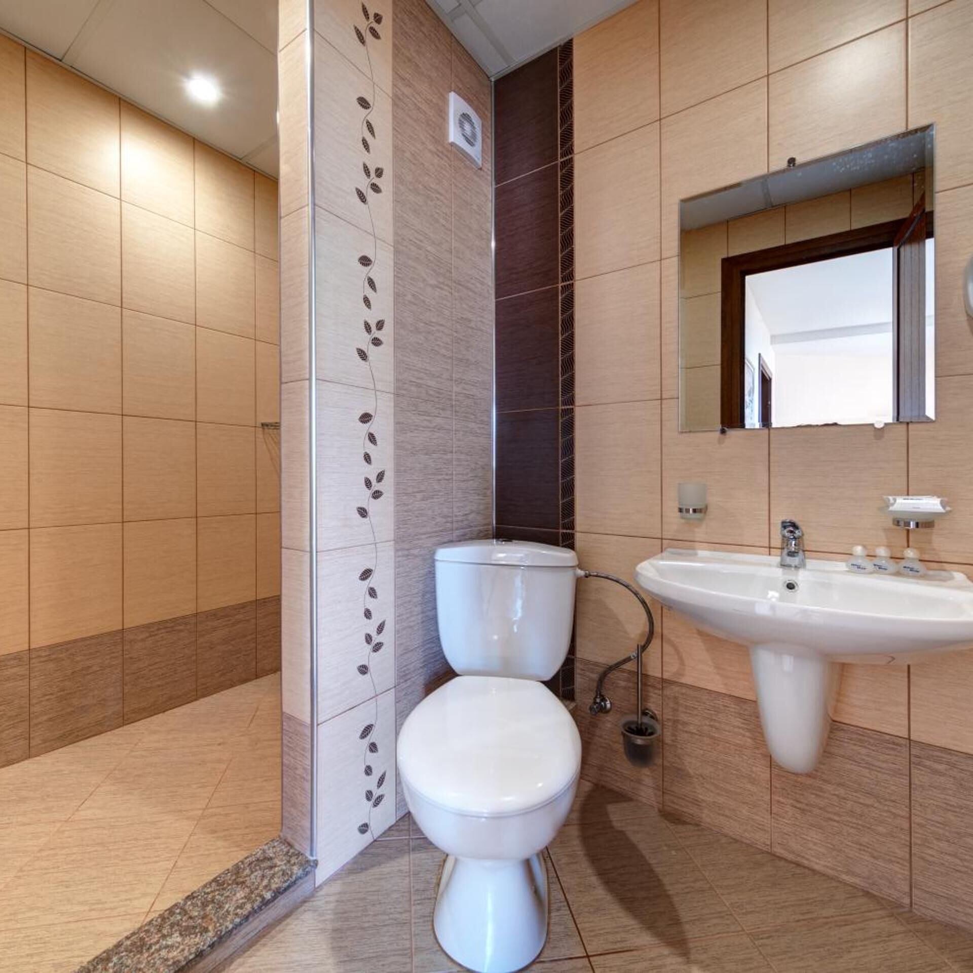 Une salle de bain moderne avec des toilettes, un lavabo et un miroir.