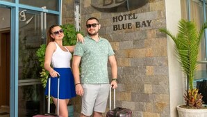 A hotel entrance with a sign reading 'HOTEL BLUE BAY' and a potted plant to the right. - Blue Bay Hotel (Nessebar)