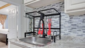 A kitchen with a stainless steel sink, a black dish rack, and a tiled backsplash. - Cozy 1-bedroom apartment in gorgeous Hartford with AC (Hartford)