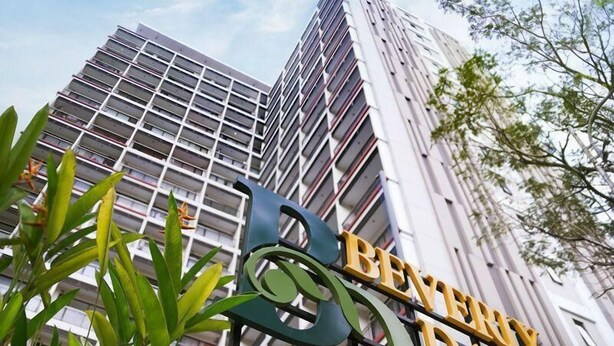 Un edificio de gran altura con un cartel que indica Beverly Dago Residence.