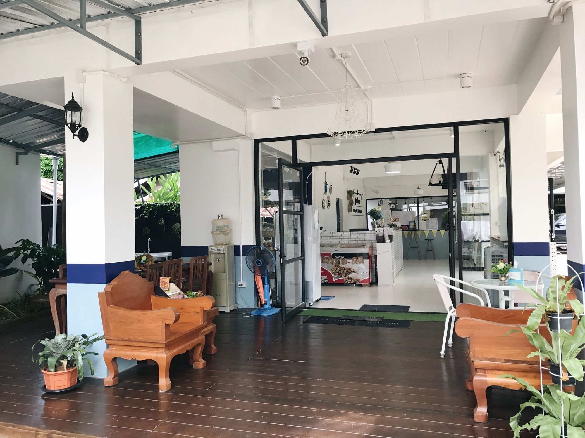 A spacious indoor area with wooden benches and potted plants.