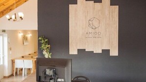 Ein Empfangsschalter mit Holzausstattung, eine Wand in Schwarz mit einem Logo und eine Kronleuchter.