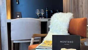 Ein modernes Hotelzimmer mit einem runden Tisch, einem Buch mit dem Titel 'MONTANO suites' und einem dekorativen Stein.