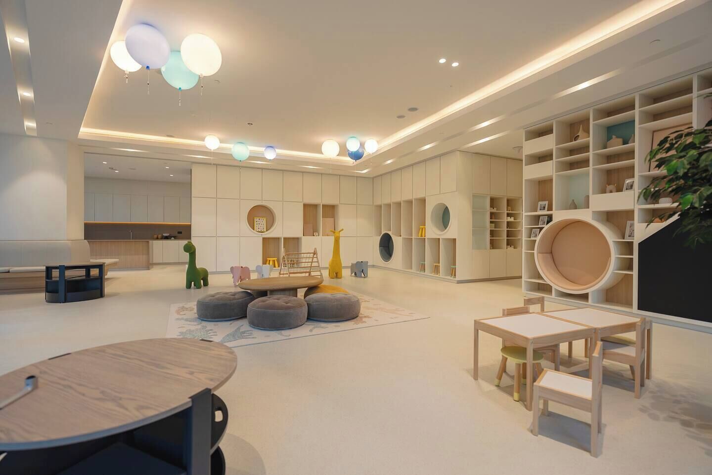 Una habitación moderna y bien iluminada con una mesa redonda, otomanes y una estantería.
