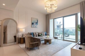A modern living room with a sofa, coffee table, and a large window with a view of buildings. - Burj Khalifa and Fountain View | Luxury Furnished! (Dubai)