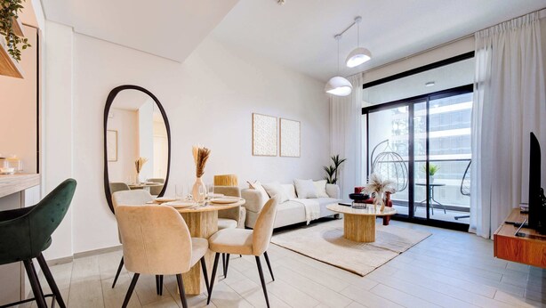 Una sala de estar moderna con comedor, ventanas amplias y un balcón.
