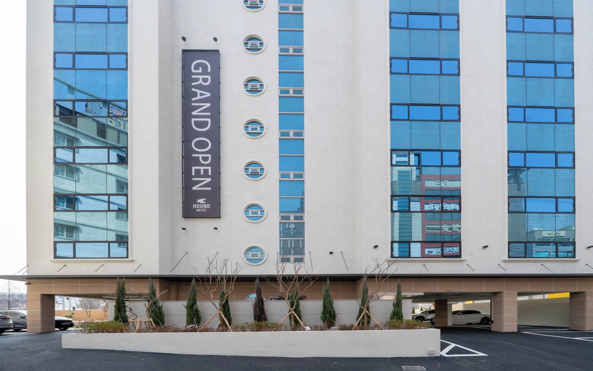 Un edificio moderno con un letrero que dice 'GRAN APERTURA' y 'HOTEL HOUND'.