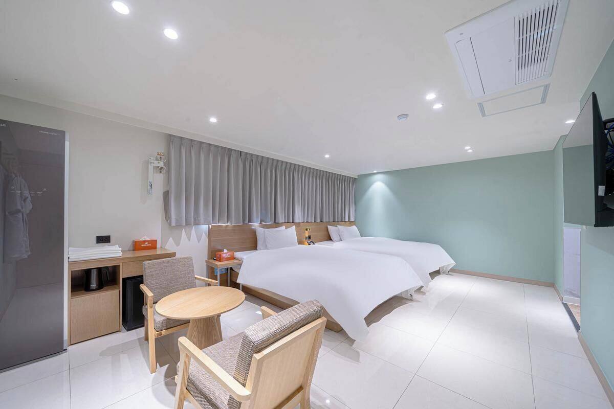 Una habitación de hotel con cama, escritorio, silla, mesa y televisor.