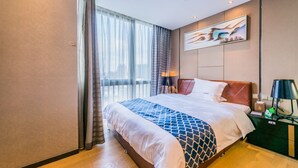 A hotel room with a large bed, a nightstand, a lamp, and a painting on the wall. - Nomo Beijing Rd.jiedenga-mall Apartment (Guangzhou)