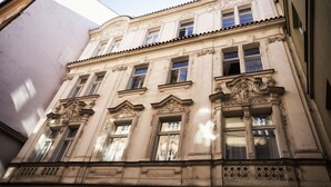 Een historisch gebouw met rijk gedecoreerde architectonische details, waaronder sierlijsten en een klassiek gevelontwerp.
