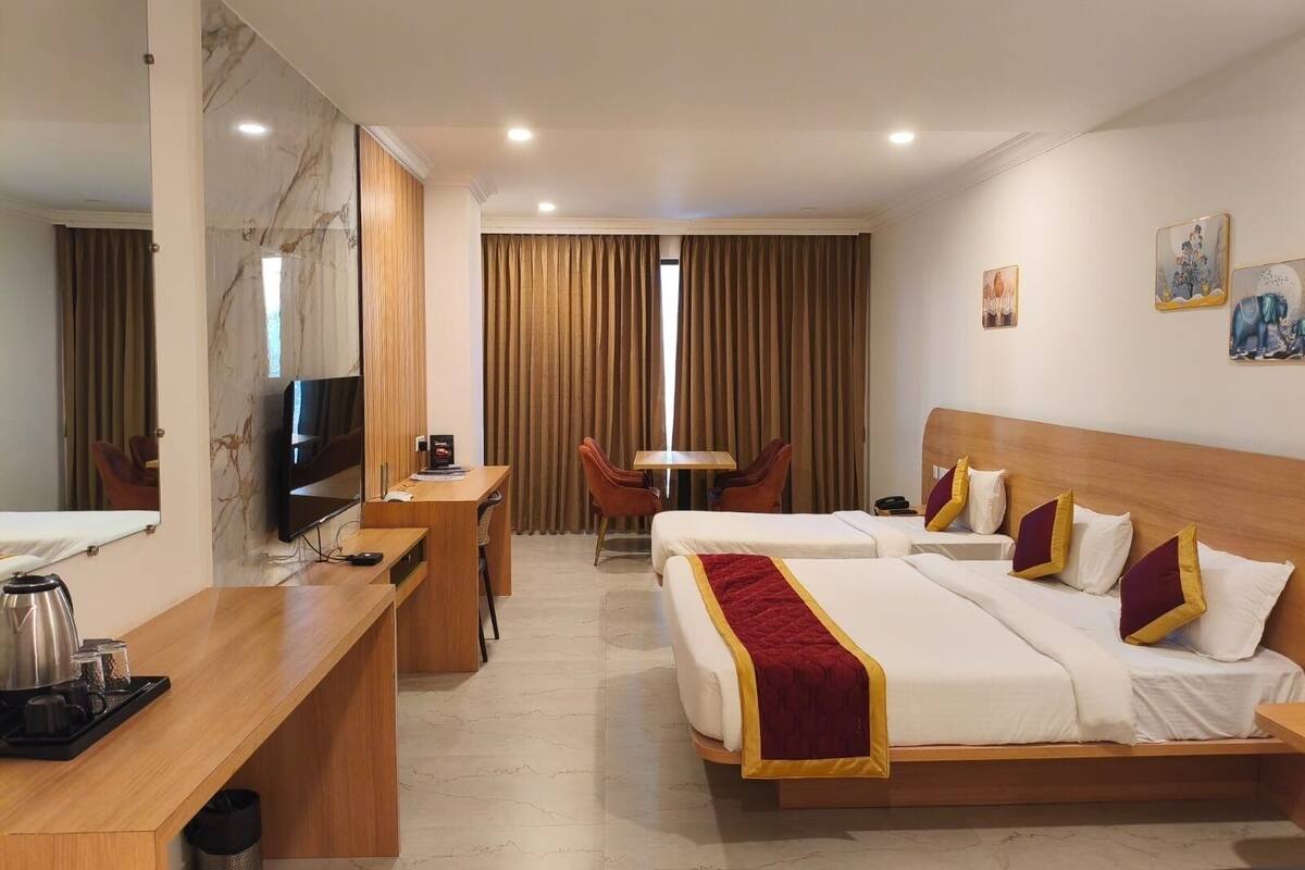 Una camera d'albergo con un letto, una scrivania, una sedia, una televisione e una macchina del caffè.