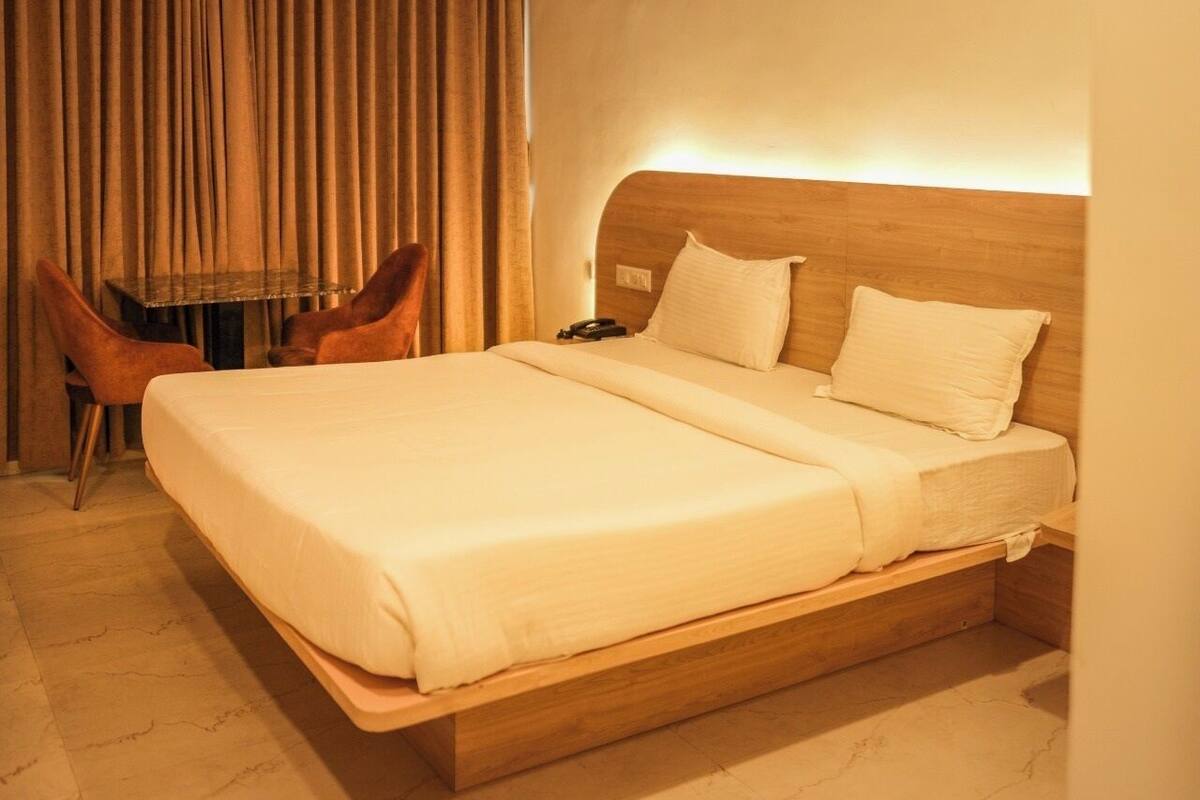 Una camera d'albergo con un letto grande, una scrivania e una sedia.