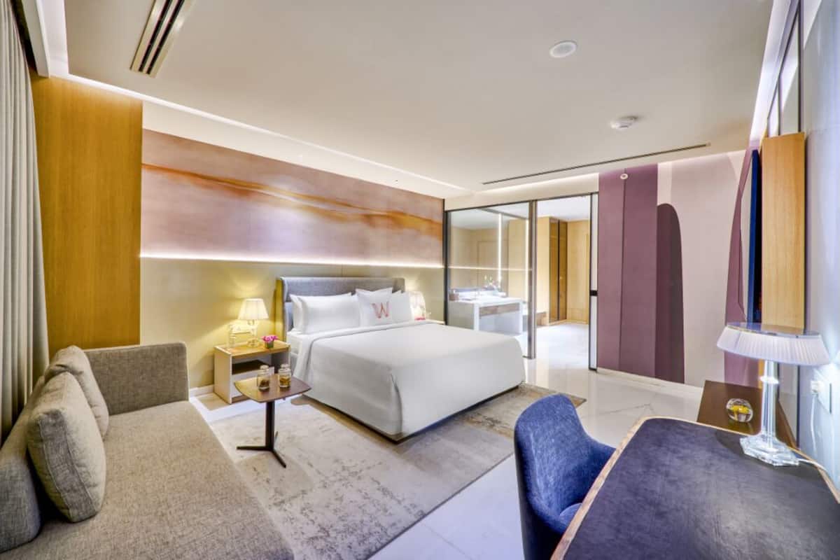 Une chambre d’hôtel moderne équipée d’un lit, d’un canapé, d’un bureau et d’une chaise.