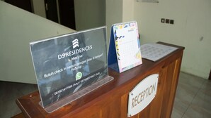 Una mesa de recepción con un cartel de DS Residences Marina, un número de teléfono y un calendario.