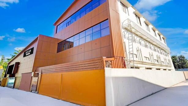 A modern hotel with a two-story structure, large windows, and a prominent entrance. - Hotel O Kundrathur Near Murugan (Chennai)