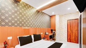 A hotel room with a large bed, a desk, and a wardrobe. - Hotel O Kundrathur Near Murugan (Chennai)