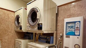 A laundry facility with two front-loading washing machines, a dryer, and a water dispenser. - Toyoko Inn Tokyo Yamanote-sen Otsuka-eki Kita-guchi No.2 (Tokyo)