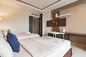 A hotel room with two beds, a desk, a TV, and a door. - Urbanview Hotel Newton Riau Bandung (Bandung)