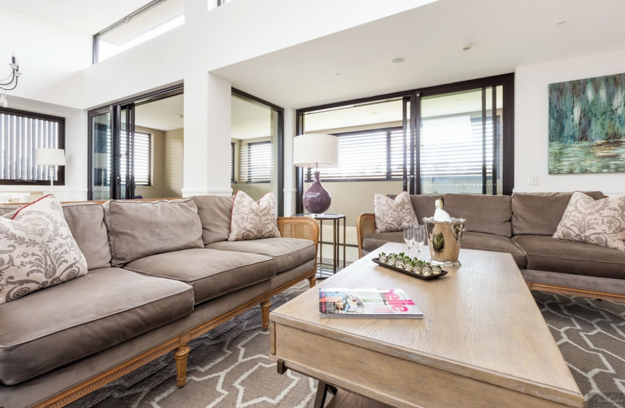 A modern living room with a sofa set, a coffee table, and a magazine.