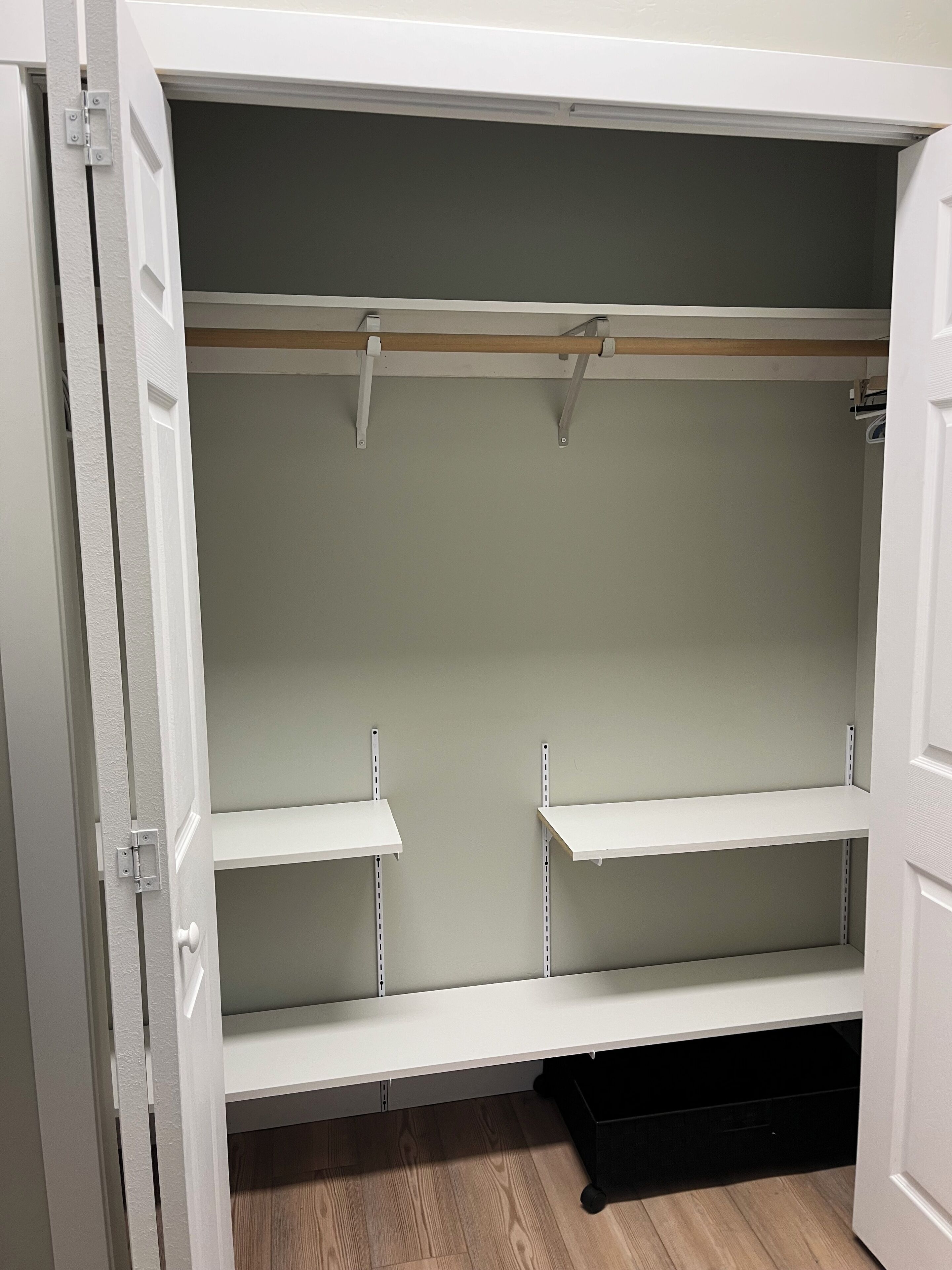 Un armario con las puertas abiertas, mostrando estantes y espacio para colgar.