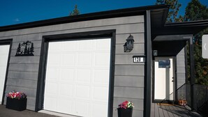 Een modern gebouw met een grote garagepoort, een brievenbus en een nummerbord met '128 B'.