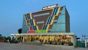 Un hotel moderno con un letrero llamativo que dice "HOTEL PRAGATI".