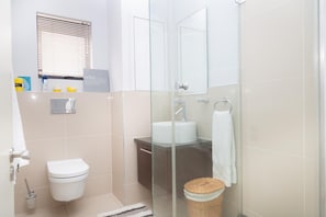 A bathroom with a toilet, sink, and shower area. - 236 Eden ON THE BAY (Cape Town)