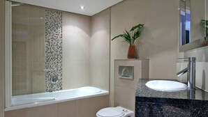 Un baño moderno con bañera, inodoro y lavamanos.