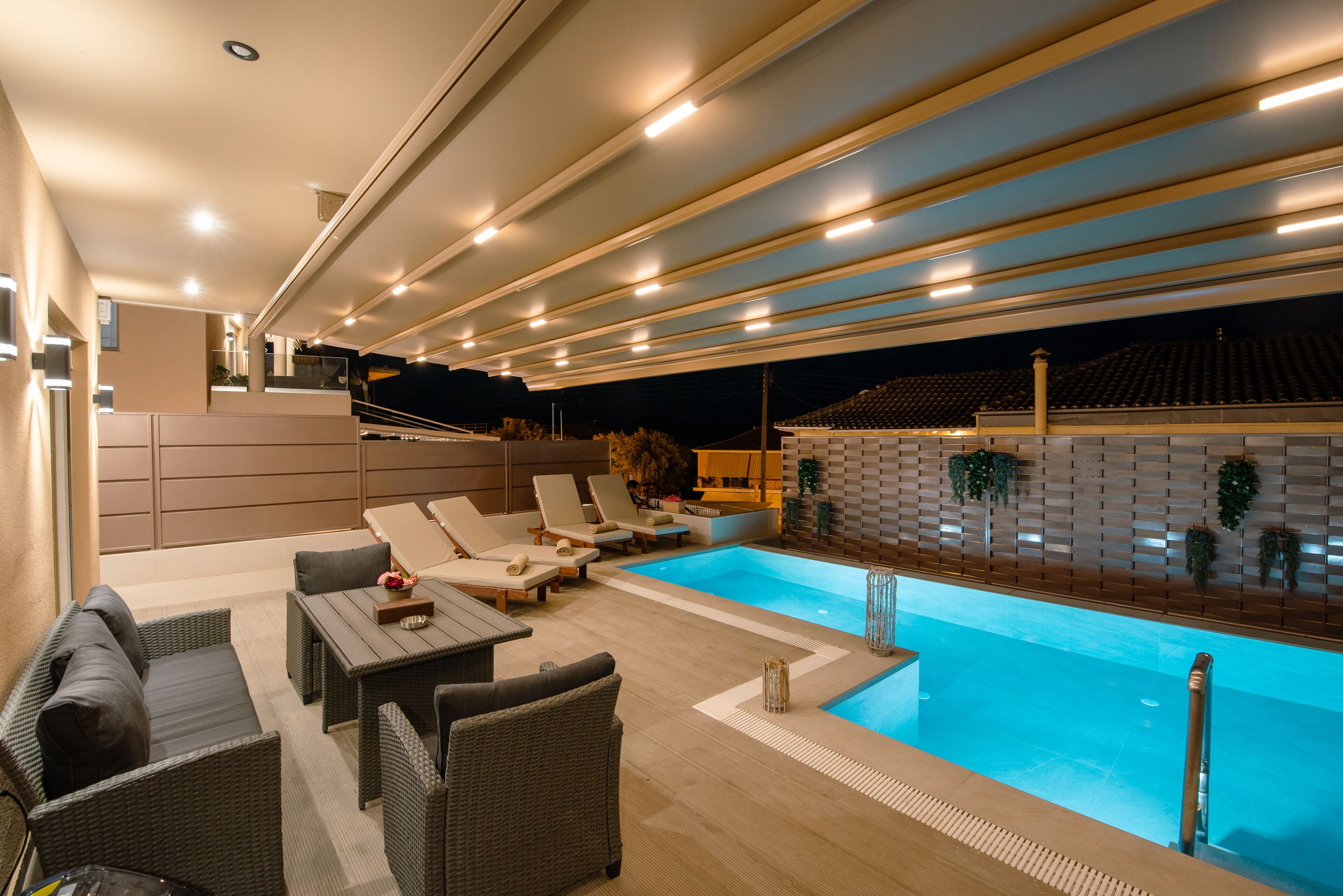 A modern outdoor pool area with lounge chairs and a wooden deck.