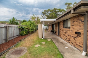 A backyard with a patio, a brick house, and a metal fence. - Entire home in Mount Warren Park, Australia (Mount Warren Park)