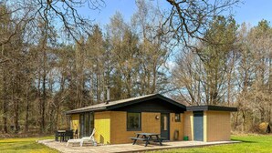 A small cabin with a patio, a table, and chairs. - 2 bedroom beautiful home in øster assels (Øster Assels)