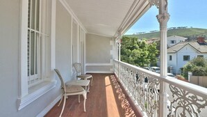 A balcony with white railings, a wooden floor, and two chairs. - Underberg House (Cape Town)